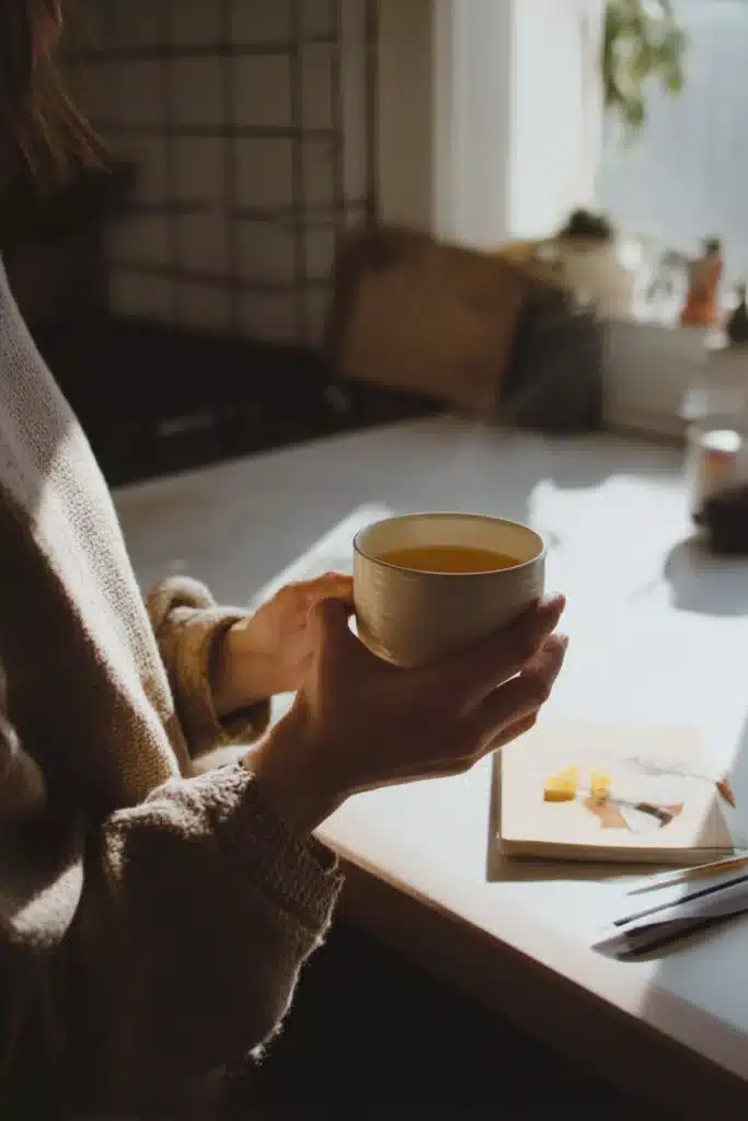 Personne tenant une tasse de recette du mounjaro naturel devant un planning de repas